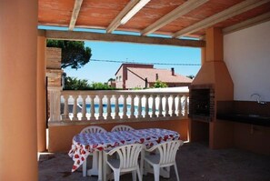 An outdoor patio with a table and chairs, a pool, and a barbecue grill. - SAONA VILLAS (VN LOUNI): villa sleeps 6, private pool, wifi, fans (Les Tres Cales)