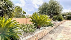 Un vialetto in pietra delimitato da un muretto basso, che conduce a un edificio con tetto piatto.