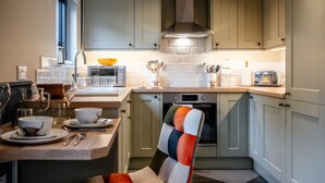 Een moderne keuken met een inbouwoven, magnetron en een ruime afzuigkap.