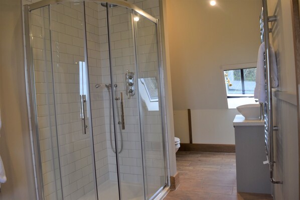 Une salle de bain moderne avec une douche à parois de verre, des toilettes et un lavabo.