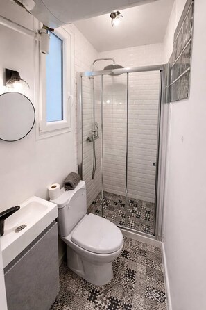 Ein Badezimmer mit Toilette, Waschbecken und Dusche.