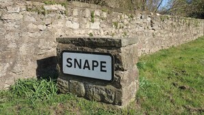 A stone wall with a sign that reads 'SNAPE.' - Castle View Cottage (Bedale)