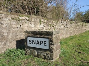 A stone wall with a sign that reads 'SNAPE.' - Castle View Cottage (Bedale)