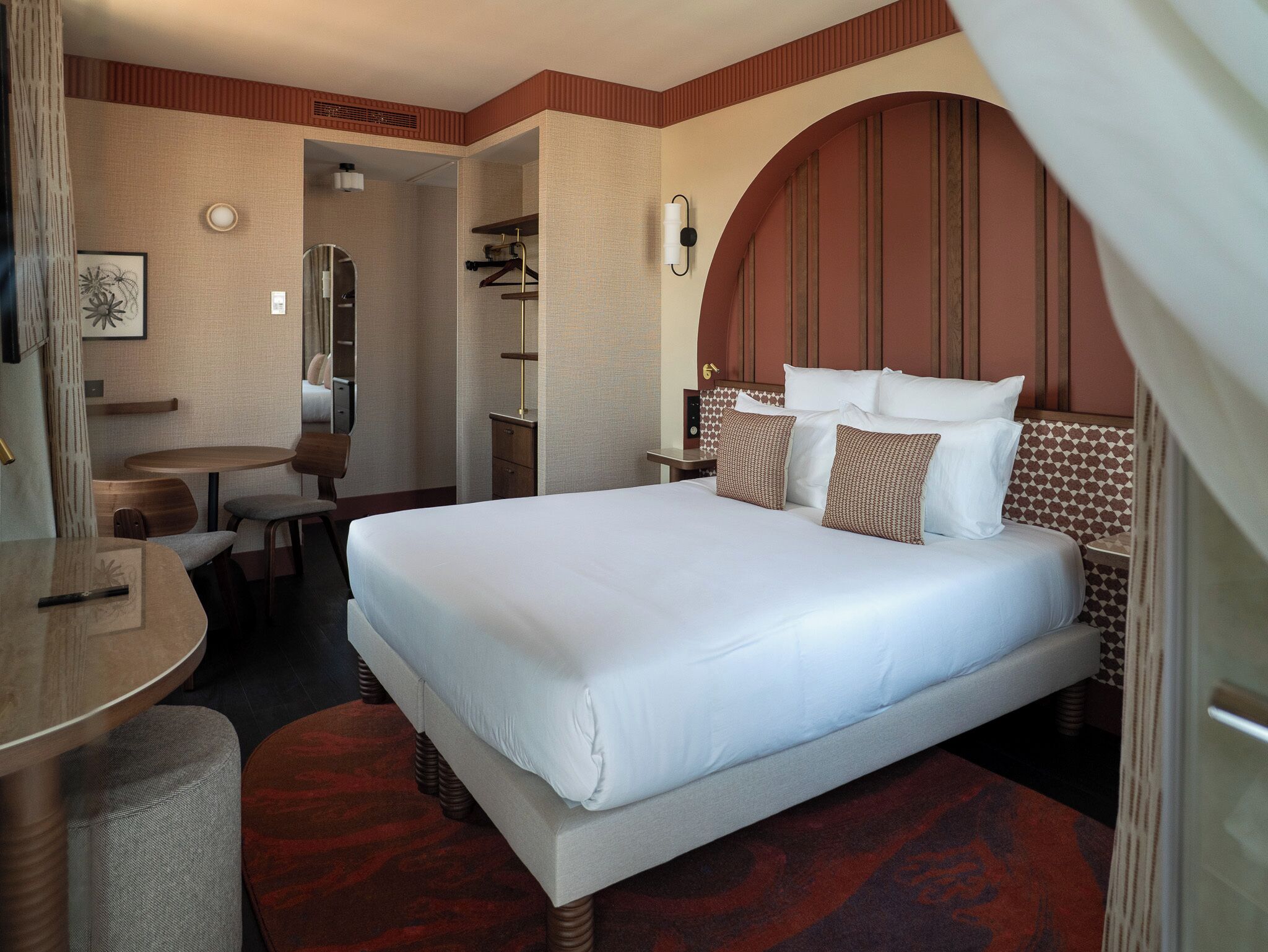 Habitación de hotel con una cama grande, un escritorio y una silla.