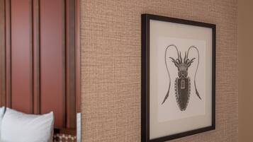 A framed artwork of a beetle on a textured wall in a hotel room.