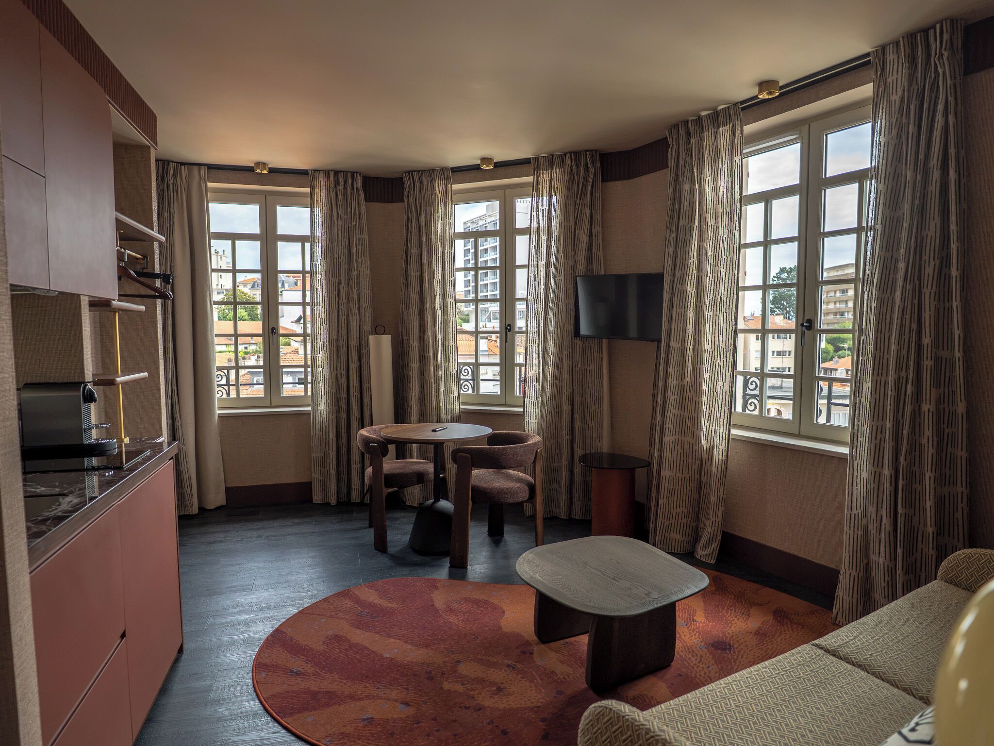 A compact living space with a kitchenette, dining area, and seating.