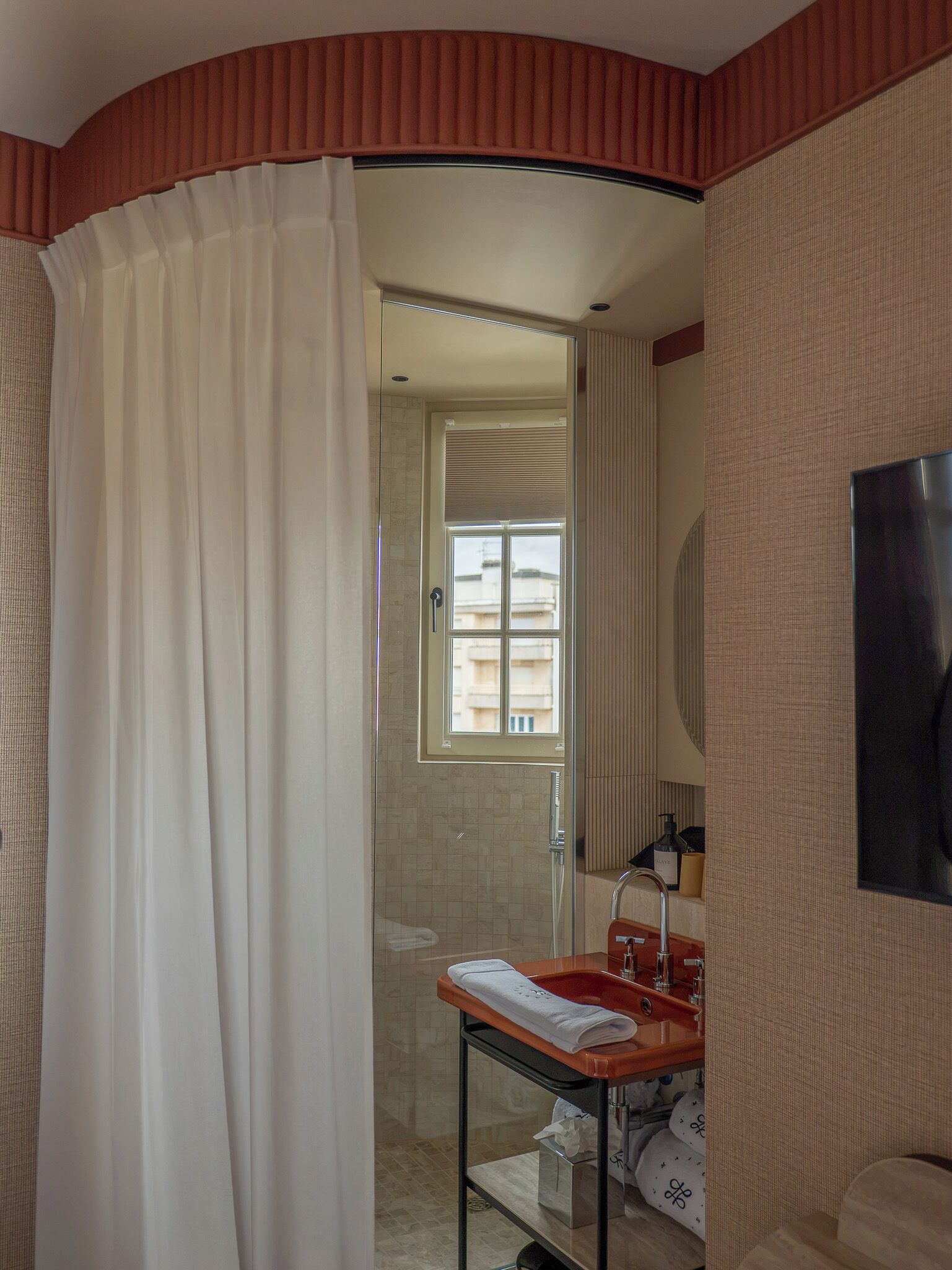 Un baño con ducha, lavamanos y espejo.