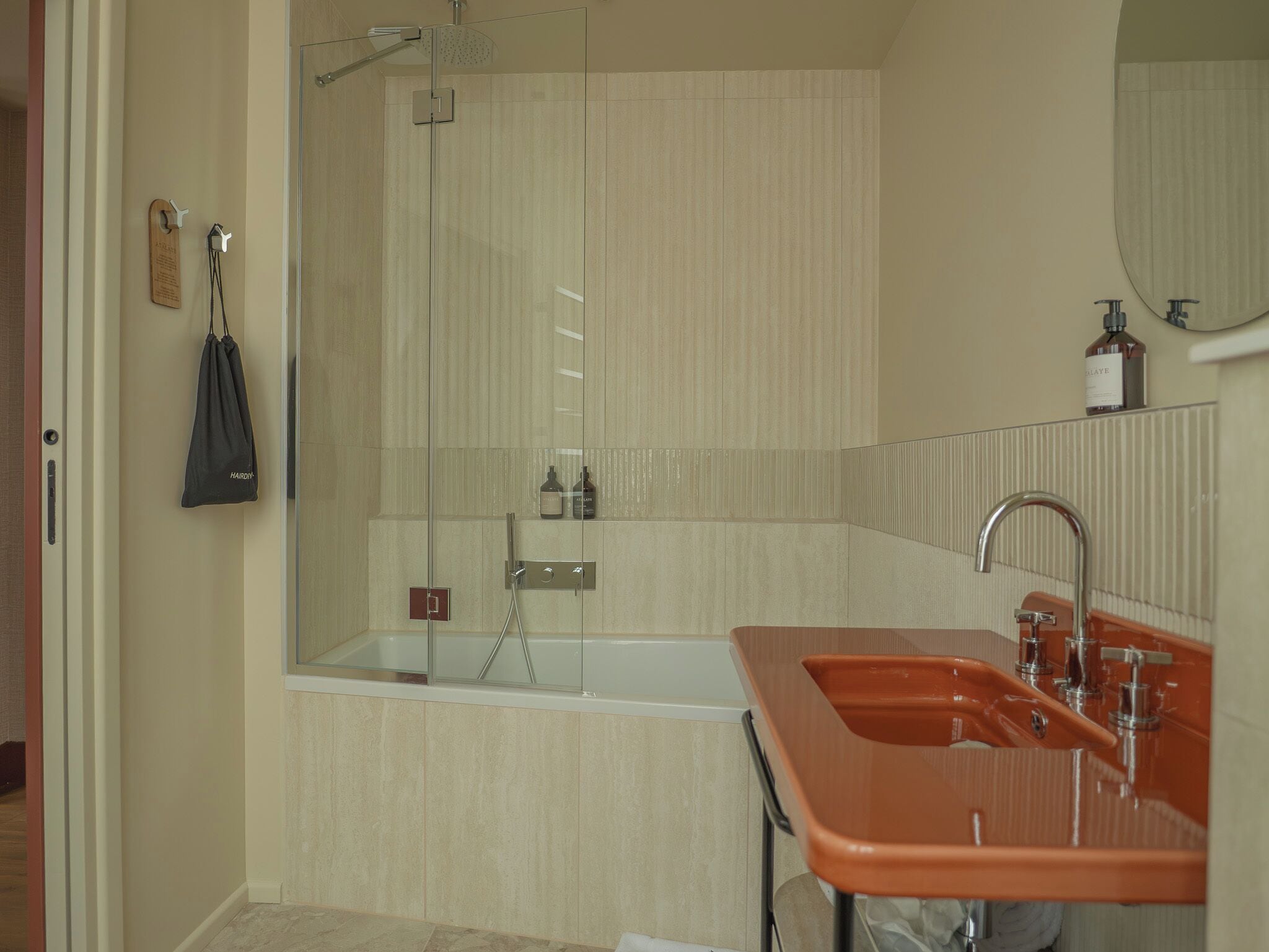 Ein Badezimmer mit Dusche, Waschbecken und Spiegel.
