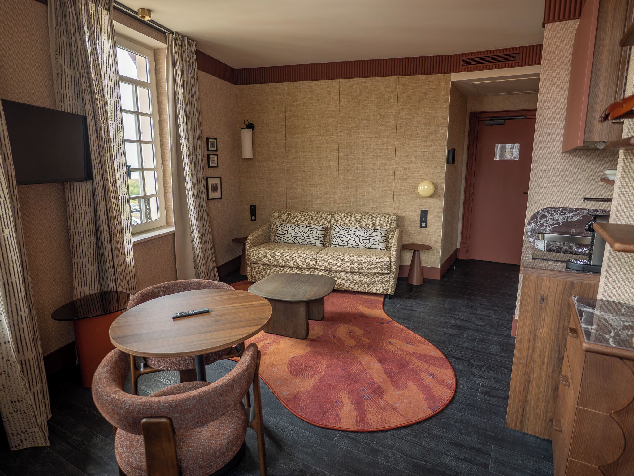 A compact living space with a sofa, a round table, and a small coffee table.