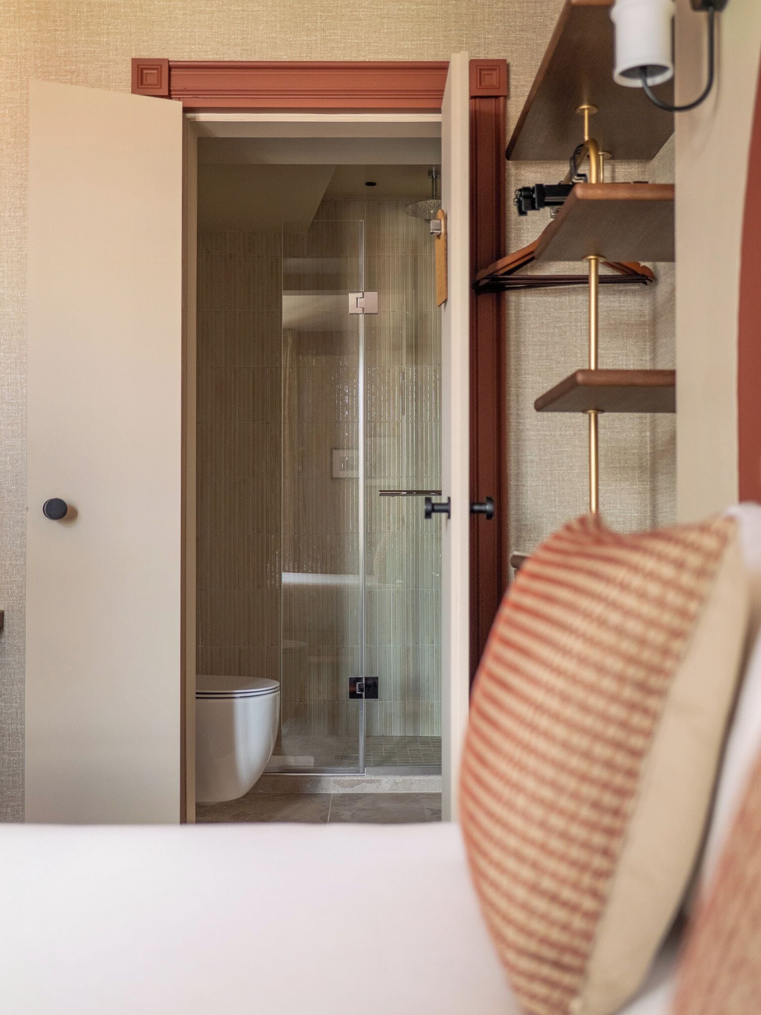 A bathroom with a toilet, a shower, and a glass door.