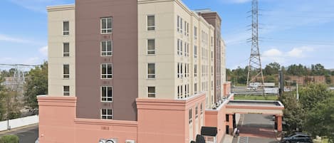 A multi-story building with a parking lot in front.