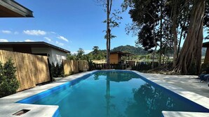 Ein rechteckiger Pool mit geschwungener Kante, umgeben von einer Betonplattform.