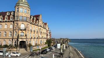 Ein historisches Gebäude mit aufwendiger Architektur, einer Uferpromenade und einem klaren Himmel.