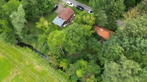 An aerial view of a house surrounded by dense greenery, with a visible driveway and parked cars. - Holiday Home for 4 People (28 m²) in Coppenbrügge / Bäntorf (Coppenbrügge)