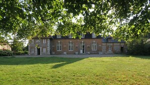 Een groot, historisch gebouw met een symmetrische gevel, veel ramen en een centrale ingang.