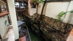 Un muro de piedra, un banco de madera y una pequeña ventana con una planta.