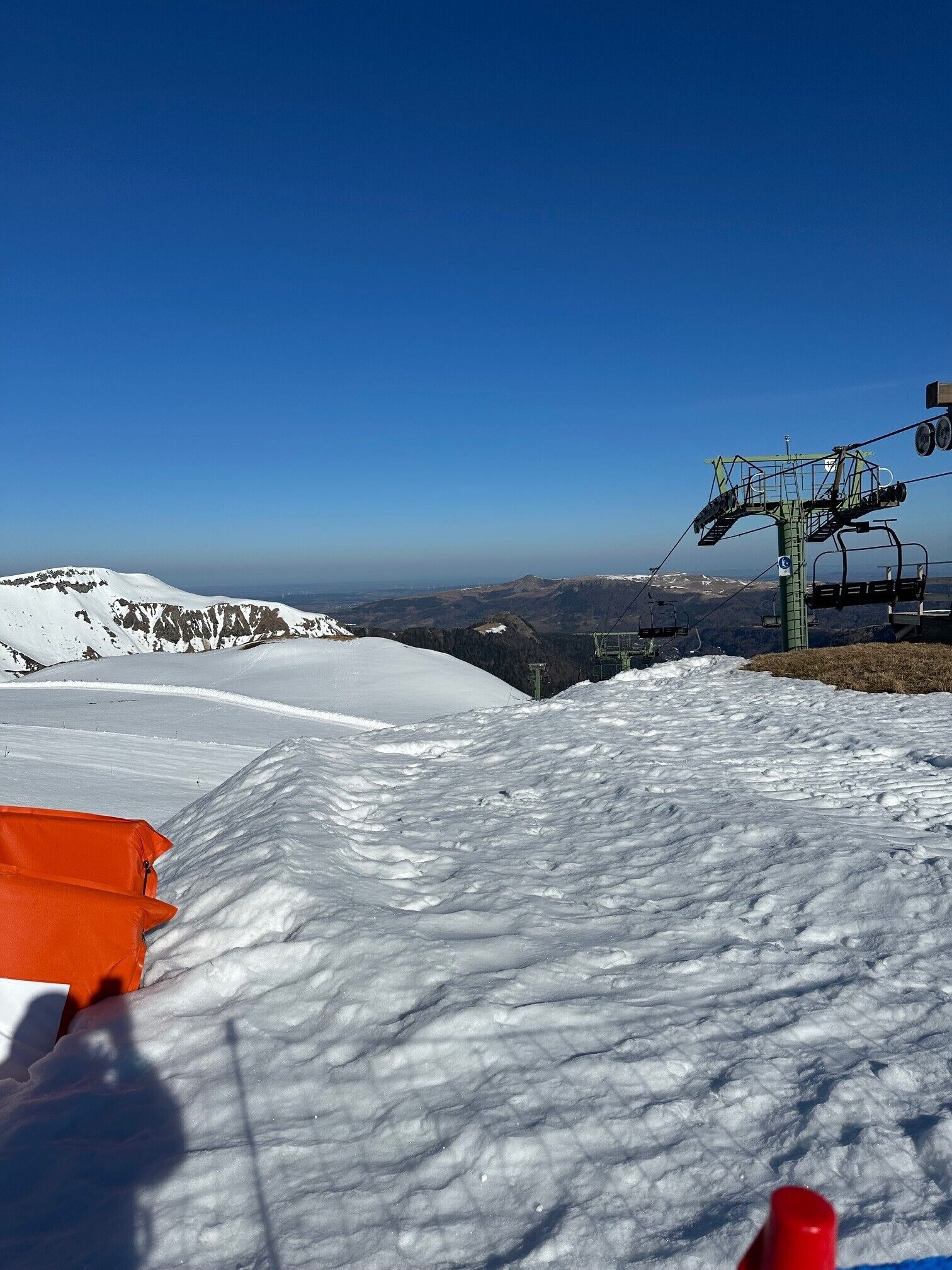 Une montagne enneigée, avec un télésiège et un télécabine.