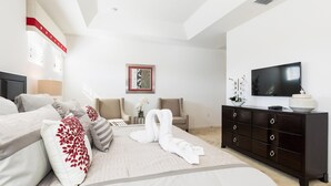 Moderni hotellihuone, jossa on suuri sänky, tumma puinen lipasto, taulutelevisio ja seinällä oleva kehystetty taulu.