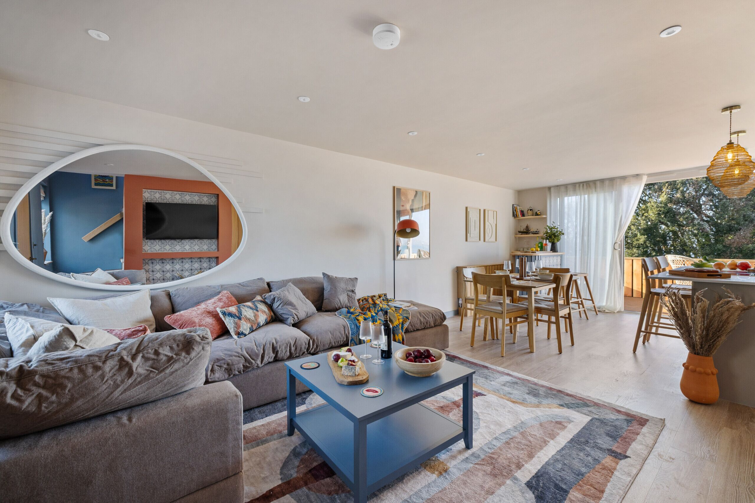 A modern living room with a sofa, coffee table, and dining area.