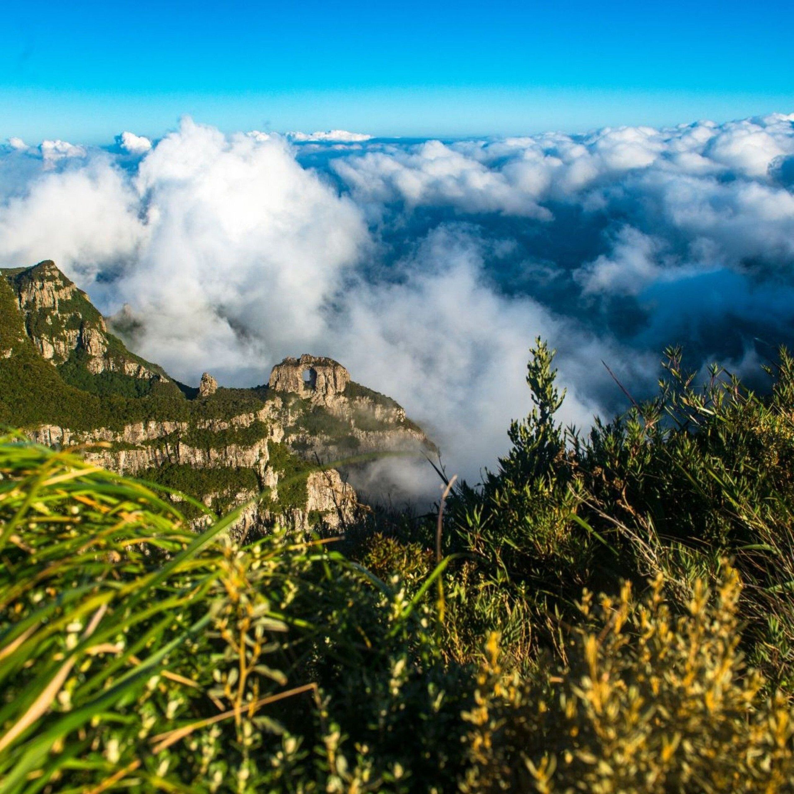 A mountainous landscape with a prominent rock formation and lush greenery.