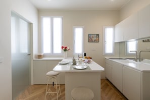 A modern kitchen with white cabinetry, a central island, and a window with a view. - Pontaccio, 19 - Your nest in town (Milano)