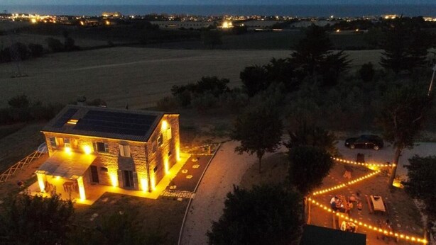 A house with a solar panel, outdoor lighting, and a paved area with a pathway. - Casa Addis B&B  (Senigallia)