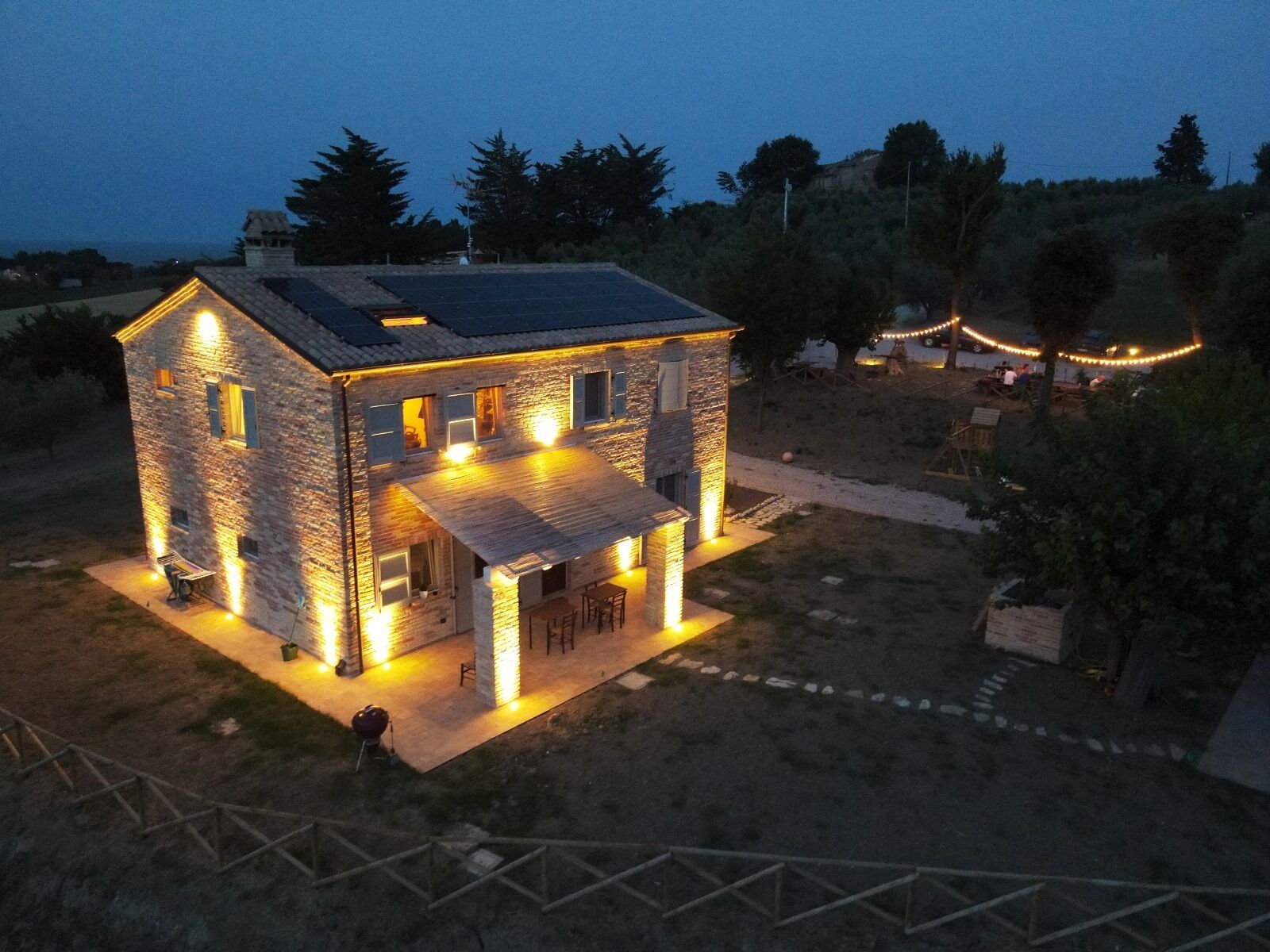 Uma casa de pedra com telhado inclinado e varanda coberta.