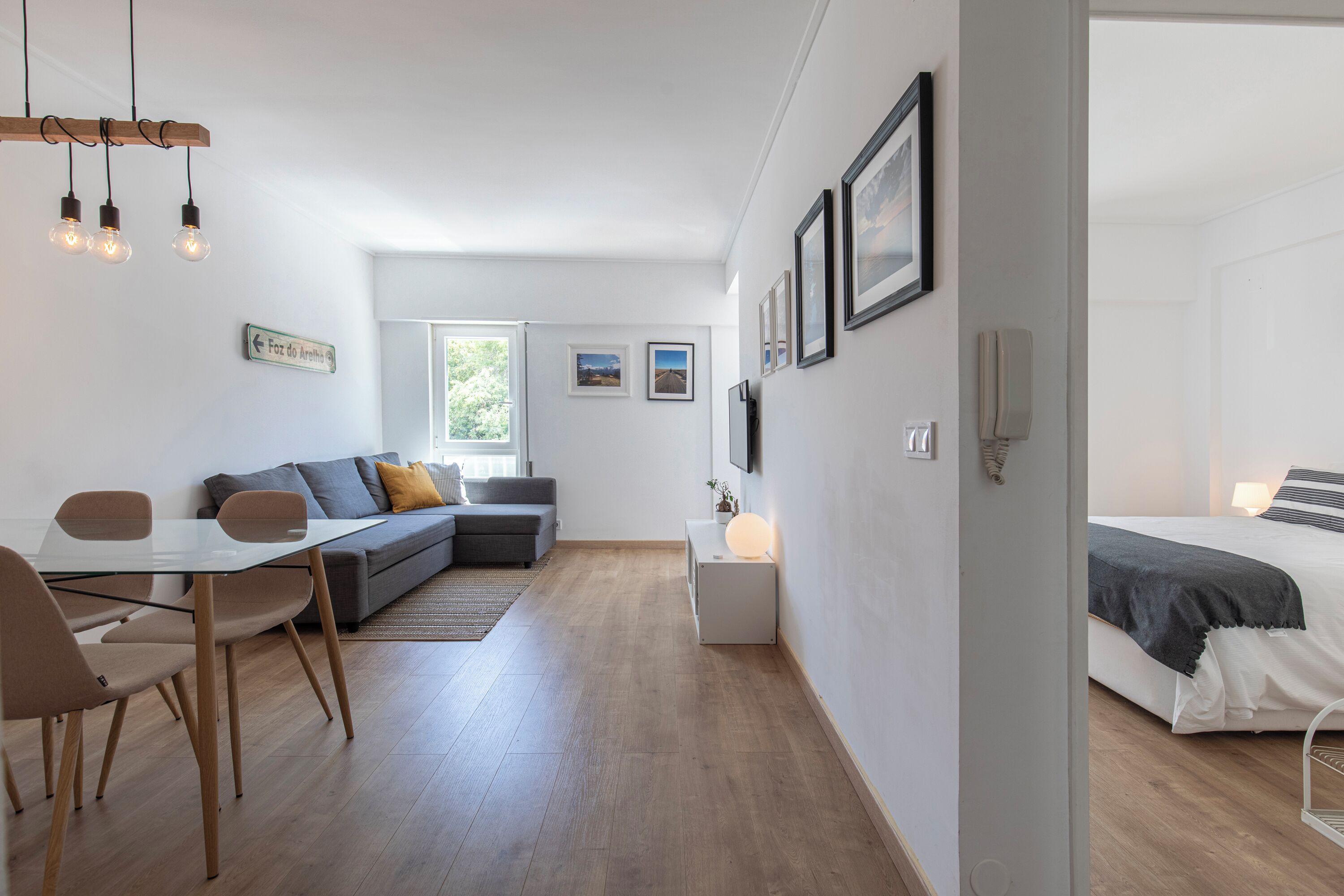 A modern interior with a dining area, sofa, and a bed.