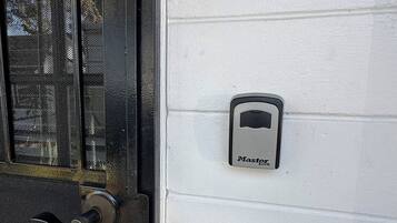 A door with a security keypad and a mesh screen.