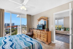 Ein Schlafzimmer mit einem großen Bett, einem Schminktisch, einem Fernseher und einem Balkon mit Blick.