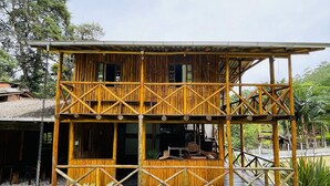 A two-story wooden building with a balcony and a covered outdoor area.