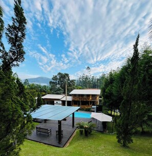 A house with a swimming pool, surrounded by trees and a clear sky. - Sitío Rústico do Zizo com Piscina (Angelina)