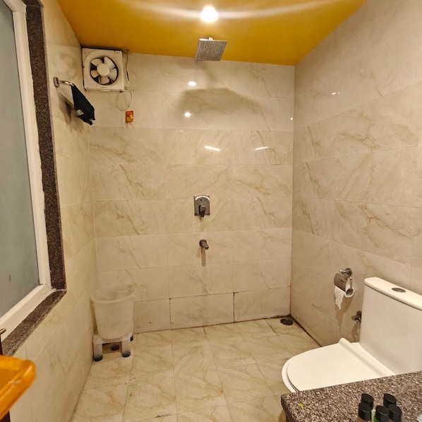 A bathroom with a shower, toilet, and sink. - Hotel Weekend Heights (Rishikesh)