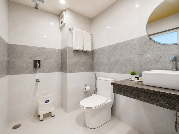 A modern bathroom with a toilet, bidet, and shower.