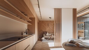 A modern kitchen with wooden cabinetry, a black countertop, and a herringbone-patterned wall. - DAS AICH - Suite Luma (Aich-Assach)
