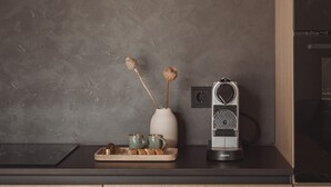 A kitchen with wooden cabinets, a countertop, and a coffee maker. - DAS AICH - Suite Sova (Aich-Assach)
