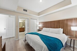 A hotel room with a bed, a nightstand, a lamp, and a wooden headboard. - Comfortable 1-Bedroom apt in Prime Orlando Spot (Orlando)