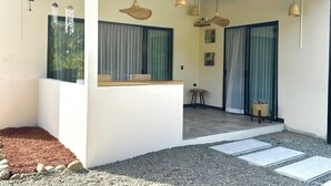 A modern house with a covered patio, large windows, and hanging light fixtures. - New Beautiful private villa with pool 10 minutes walk from Puerto Viejo. (Puerto Viejo de Talamanca)