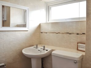 A bathroom with a sink, toilet, and a mirror. - Crag Barn Cottage (Penrith)