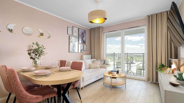 Una sala de estar moderna con comedor, ventanas amplias y un balcón.