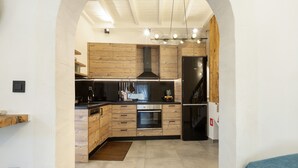Une cuisine moderne avec des meubles en bois, un four encastré et une hotte de cuisson en acier inoxydable.
