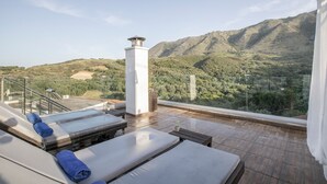 A rooftop terrace with sun loungers, a white column, and a view of a mountainous landscape. - Apartment 'Modern' with Mountain View, Wi-Fi and Air Conditioning (Chania)