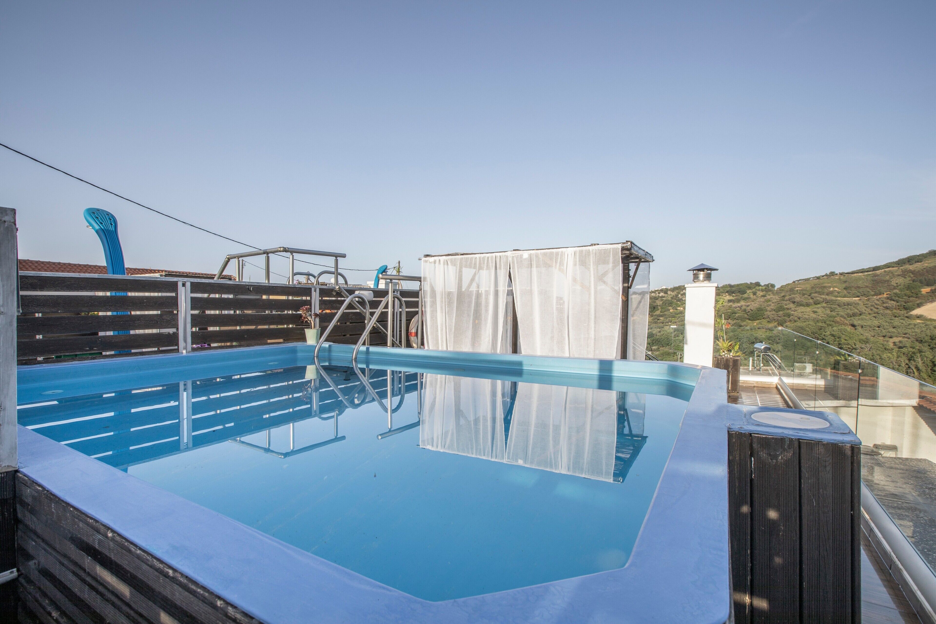 Ein Infinity-Pool auf dem Dach mit freiem Blick auf die umliegende Landschaft.