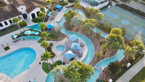 Un'area piscina con diverse piscine, lettini e ombrelloni.