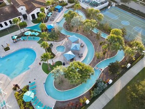 A swimming pool area with multiple pools, lounge chairs, and umbrellas. - Last Minute Disney Getaway! Luxury Villa with Private Pool, Game Room & Themed Bedrooms. Book Now! #152563 (Orlando)