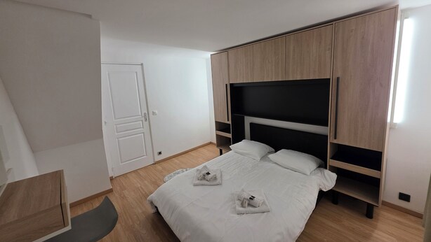 Ein Schlafzimmer mit Bett, Schreibtisch und Kleiderschrank.