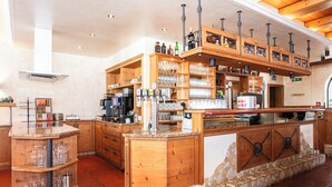 A bar area with wooden shelves, a stone base, and a coffee machine. - Centrally located apartment hotel, right next to the cable car, wellness breakfast (Werfenweng)