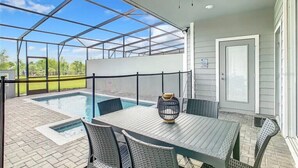 Eine überdachte Terrasse mit Pool, Sitzgelegenheiten im Freien und einem Deckenventilator.
