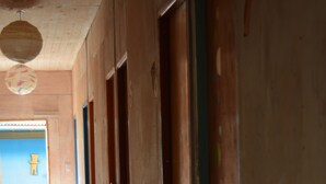 A corridor with doors, a cross on the wall, and a door labeled '7'. - Glamping Tilcara El Obrador (Tilcara)