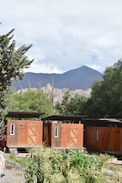 Una hilera de cabañas con una montaña al fondo.